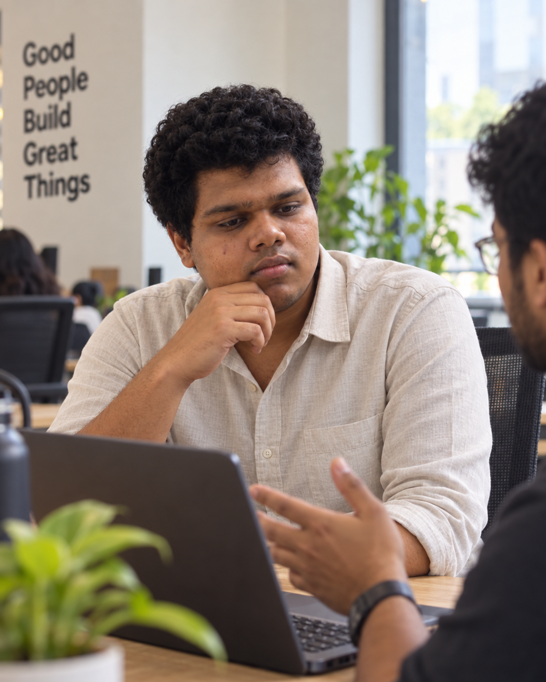 Conceptual candid-style portrait of Yethikrishna R, founder of Mynd Labs, listening during a discussion at a workspace.