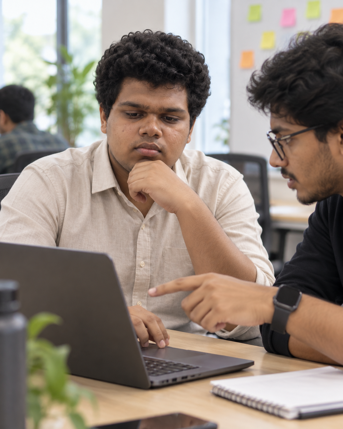Conceptual candid-style portrait of Yethikrishna R debugging with another person at a laptop in a workspace setting.